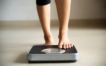 Female leg stepping on weigh scales. Healthy lifestyle, food and